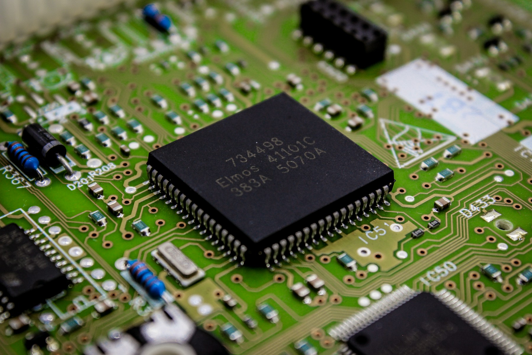 Close-up of a chip and surrounding components on a printed circuit board.